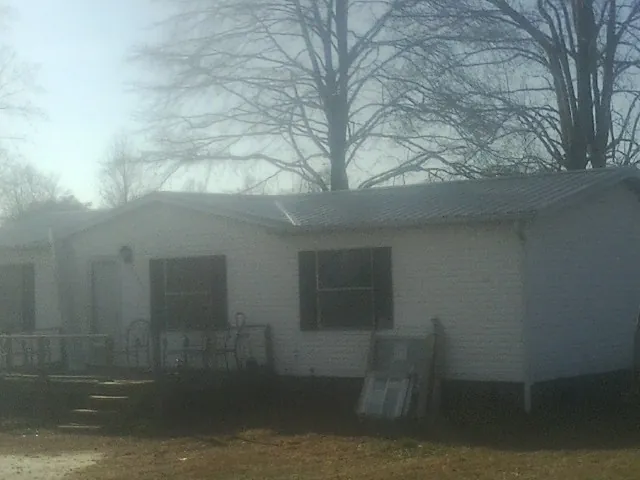 New metal roof on a white painted brick home on a foggy morning in Danville